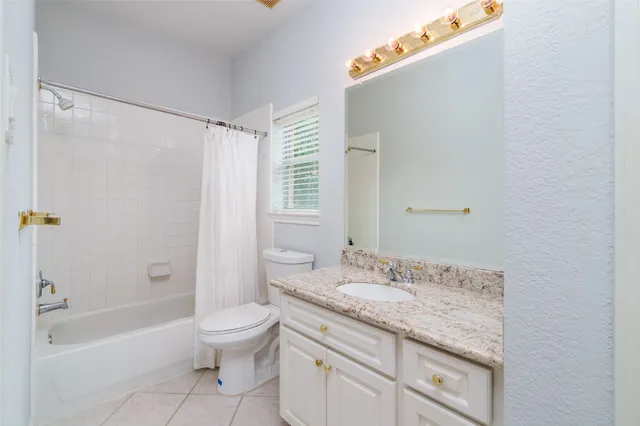a bathroom with a granite countertop sink a toilet and shower