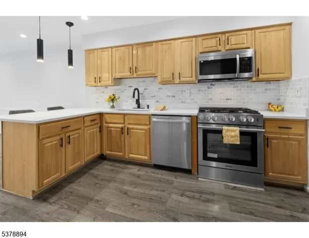 a kitchen with stainless steel appliances a stove a sink and a microwave