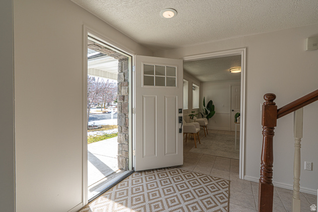 1045 Fox Farm Road Logan, UT 84321 - Photo 9 of 65 Foyer featuring a textured ceiling, light tile patterned floors, and stairway