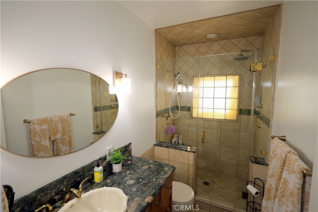 226 Orizaba Avenue Long Beach, CA 90803 - Photo 22 of 39 a bathroom with a granite countertop sink mirror vanity and toilet