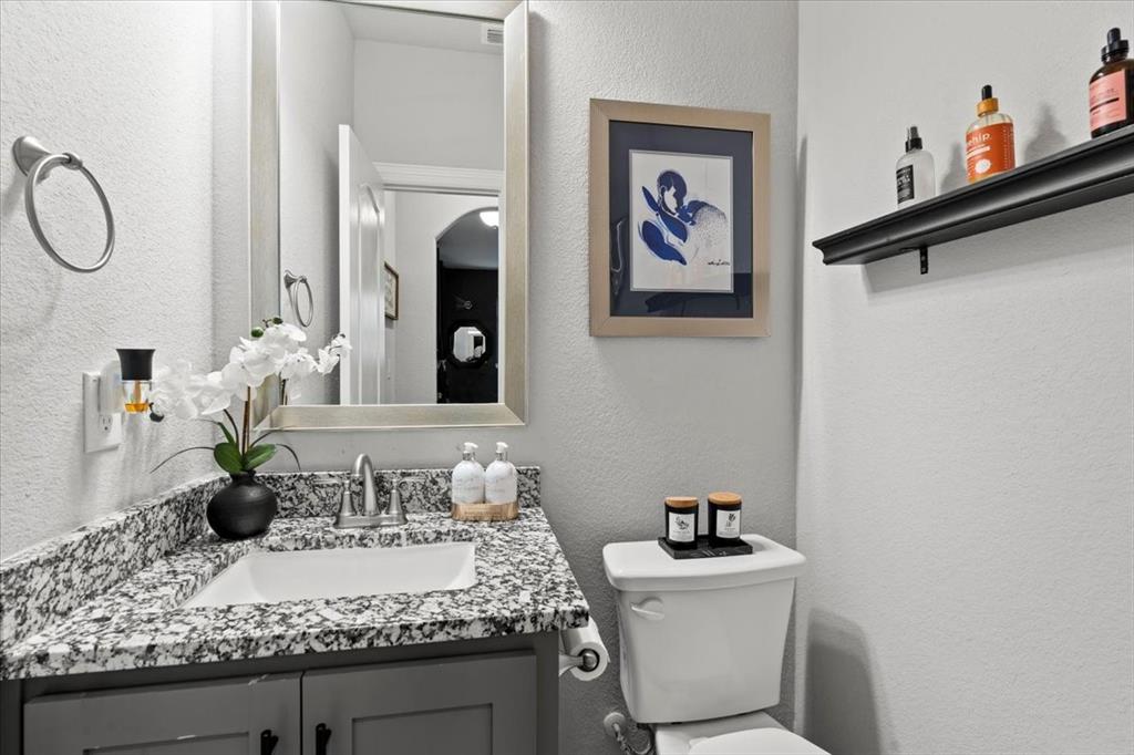 620 Shadow Trail Frisco, TX 75033 - Photo 34 of 36 Vanity featuring a white basin, speckled countertop, and gray cabinetry