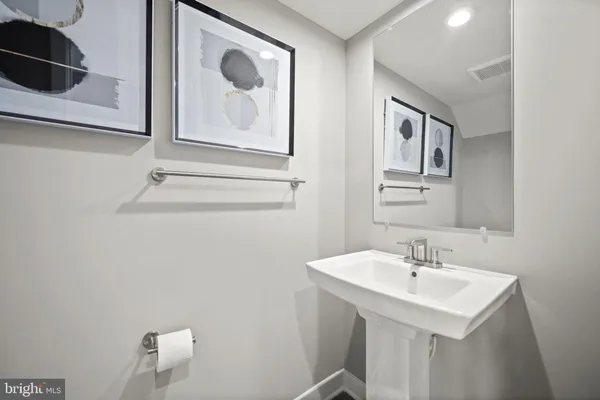 a bathroom with a sink a toilet and mirror