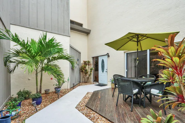 a patio with a table and chairs under an umbrella