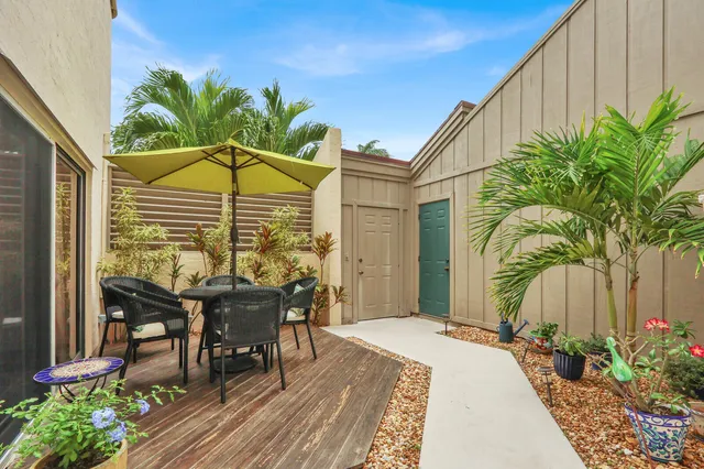 a view of a chairs and table in patio with potted plants