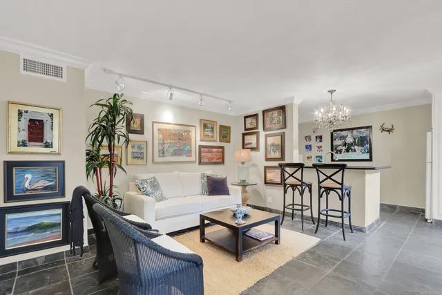 a living room with furniture a table and kitchen view