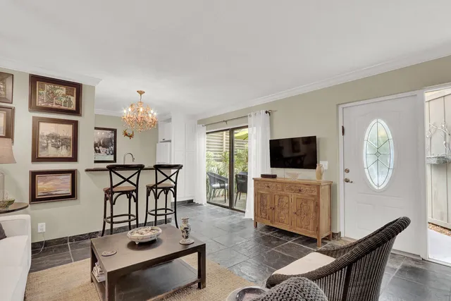 a living room with furniture a flat screen tv and kitchen view
