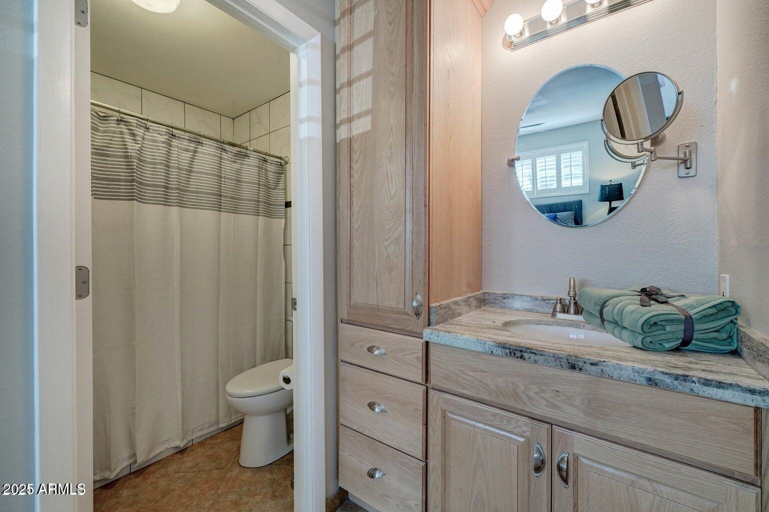 5525 East Thomas Road, Unit H3 Phoenix, AZ 85018 - Photo 3 of 7 a bathroom with a granite countertop sink mirror and vanity