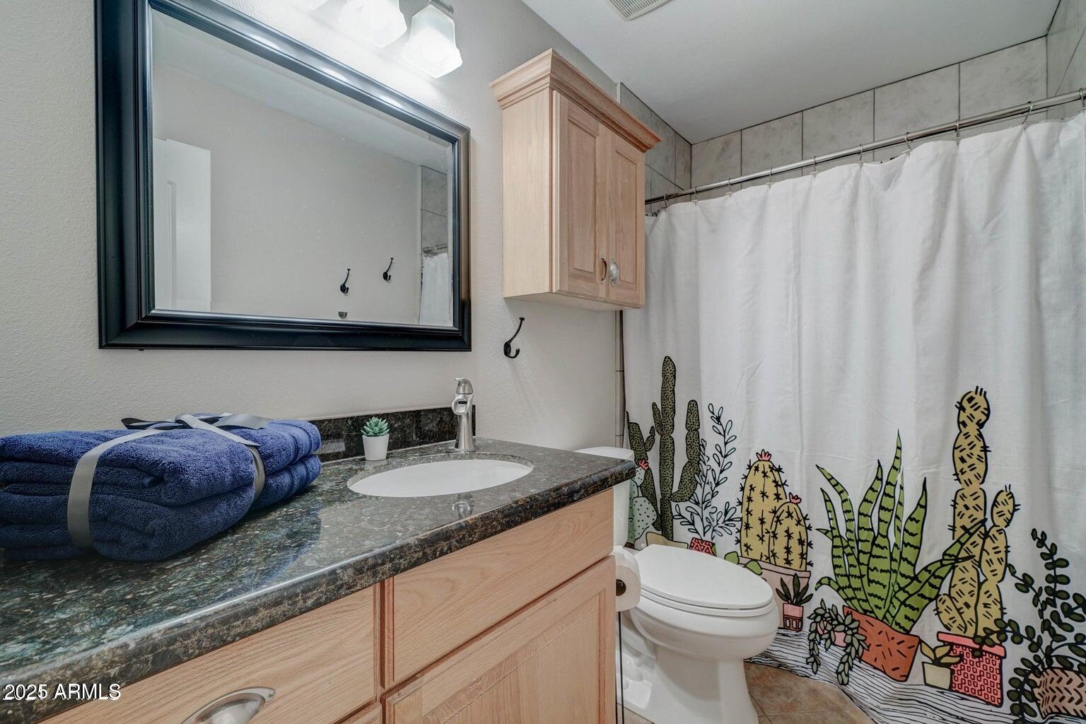 5525 East Thomas Road, Unit H3 Phoenix, AZ 85018 - Photo 5 of 7 a bathroom with a granite countertop sink and a toilet