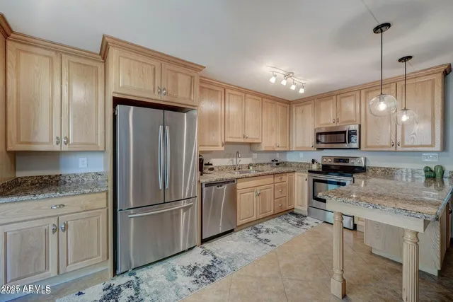 a kitchen with granite countertop a refrigerator sink and cabinets