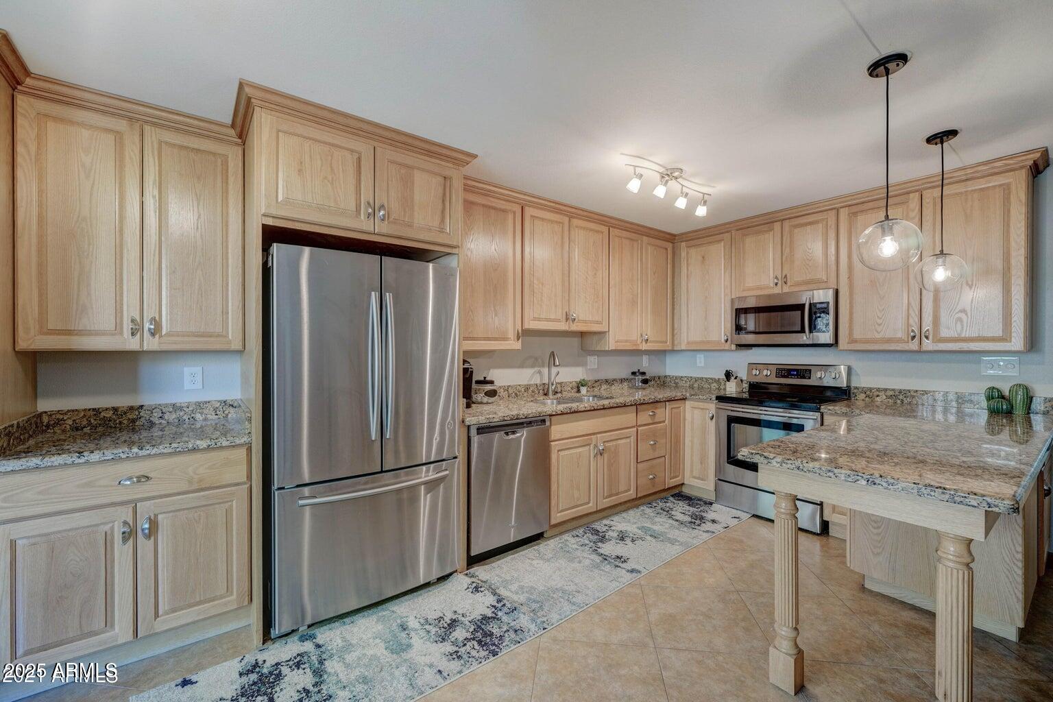 5525 East Thomas Road, Unit H3 Phoenix, AZ 85018 - Photo 7 of 7 a kitchen with granite countertop a refrigerator sink and cabinets