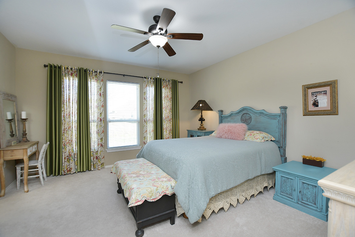 212 Bonham Loop Georgetown, TX 78633 - Photo 15 of 21 Nicely separated from the guest bedroom up front, the primary bedroom at the rear of the home enjoys views of the open space behind.