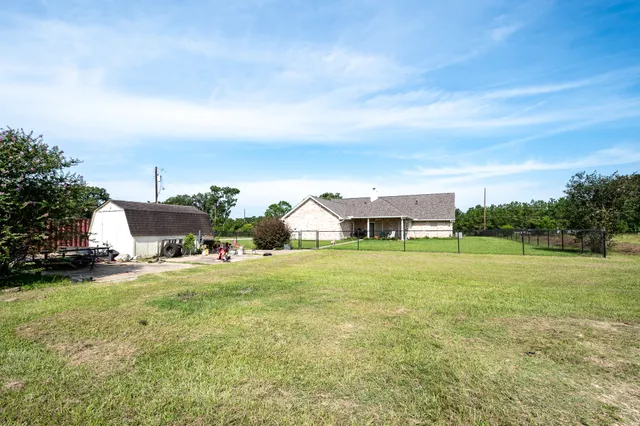 a view of a house with a big yard and a large tree