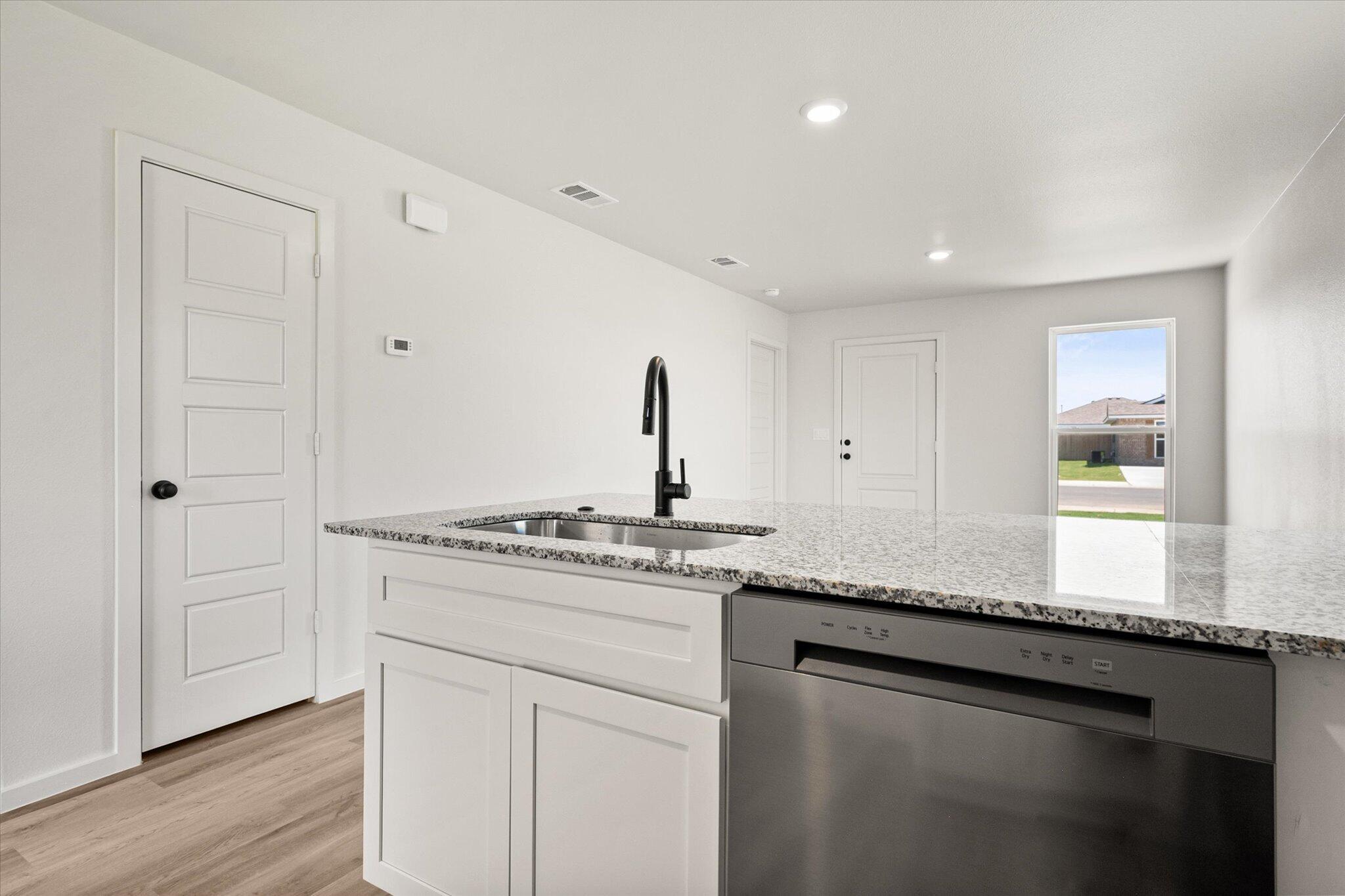 8312 25th Street Lubbock, TX 79407 - Photo 11 of 17 a kitchen with stainless steel appliances granite countertop a sink and a stove next to a window