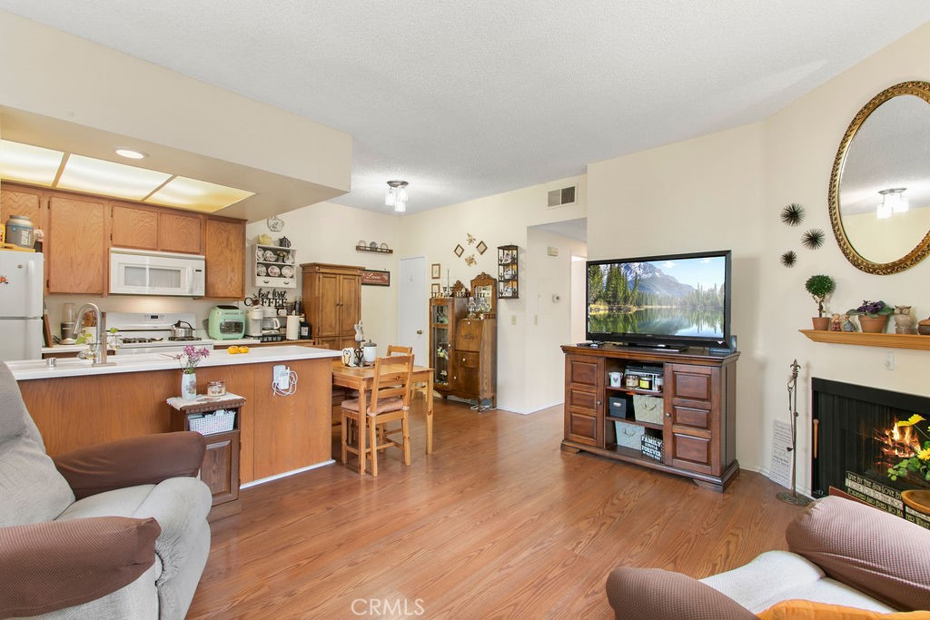 10411 Garden Grove Boulevard, Unit 43 Garden Grove, CA 92843 - Photo 2 of 22 a living room with furniture a fireplace a flat screen tv and kitchen view
