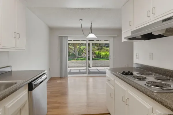 a kitchen with a stove a sink and a granite counter tops