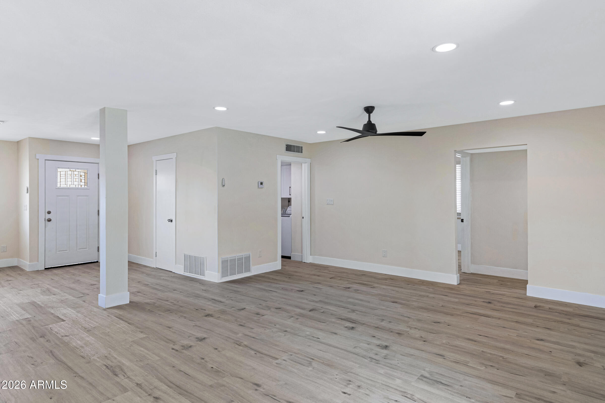 3921 South Kenneth Place Tempe, AZ 85282 - Photo 12 of 43 an empty room with wooden floor and windows