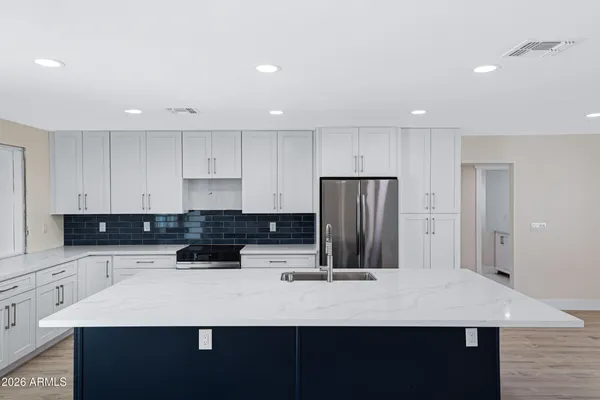 a kitchen with a refrigerator and a stove top oven