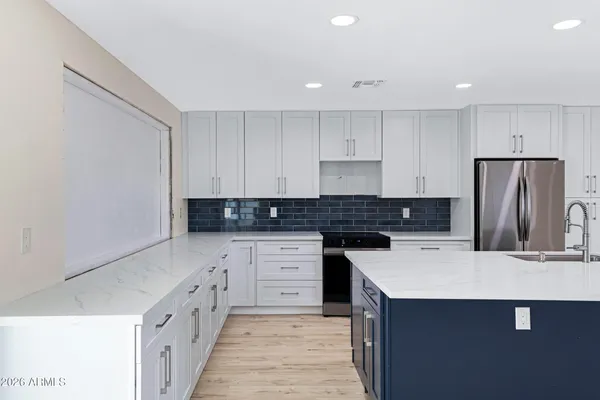 a kitchen with stainless steel appliances a sink stove and refrigerator
