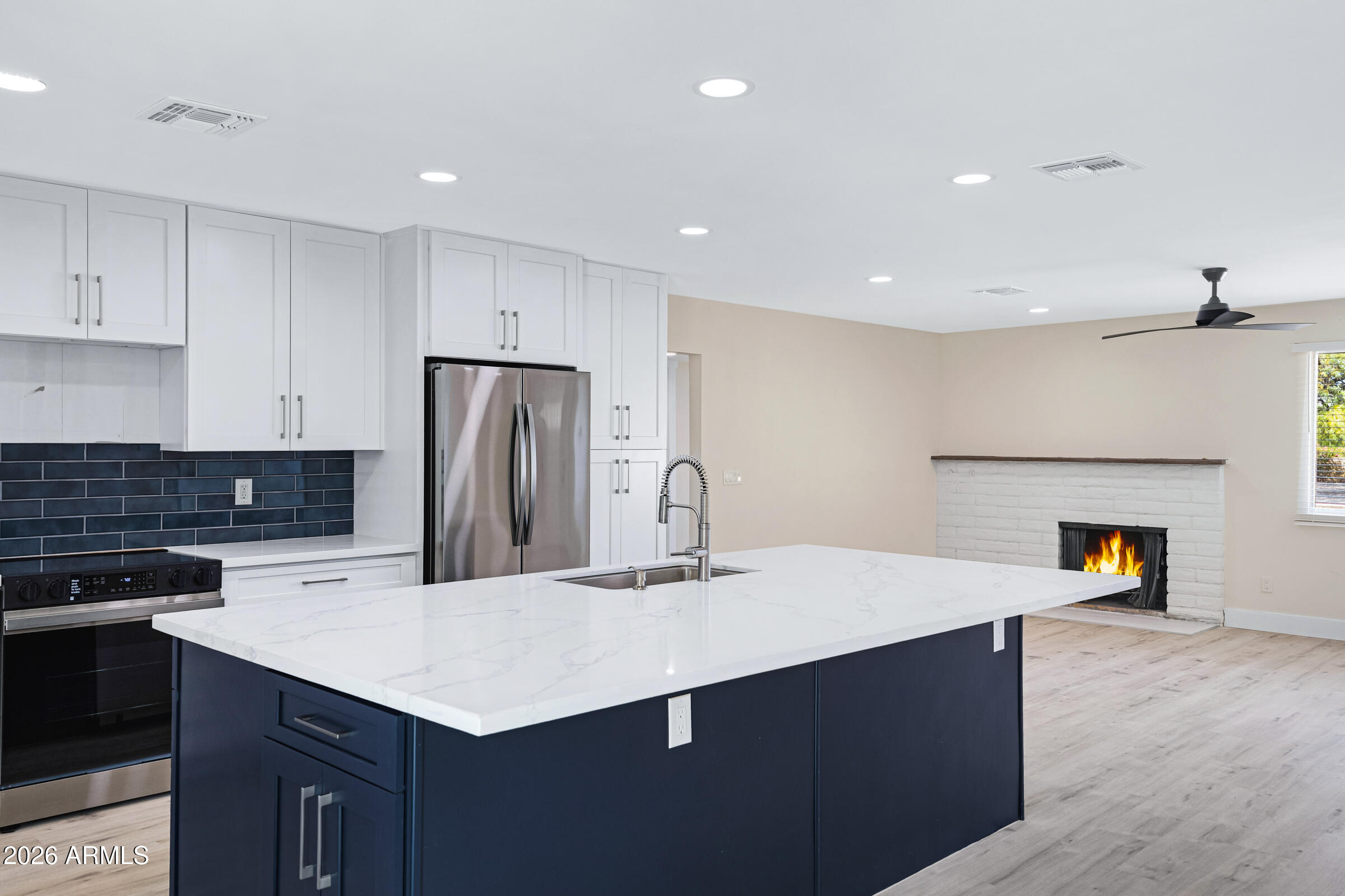 3921 South Kenneth Place Tempe, AZ 85282 - Photo 16 of 43 a kitchen with a sink a refrigerator and a stove top oven with wooden floor