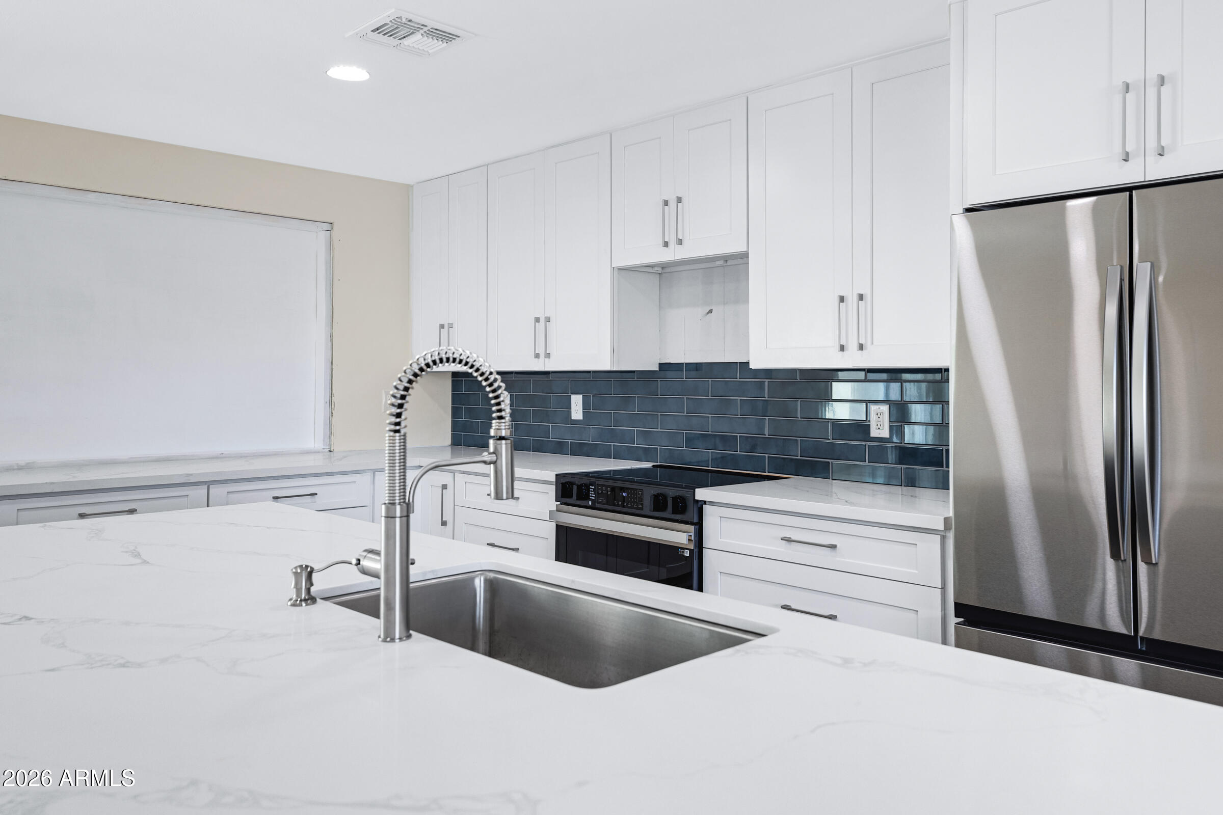 3921 South Kenneth Place Tempe, AZ 85282 - Photo 17 of 43 a kitchen with granite countertop a refrigerator and a stove top oven