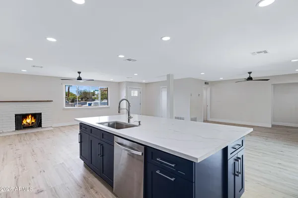 a kitchen with a sink a counter space and wooden floor