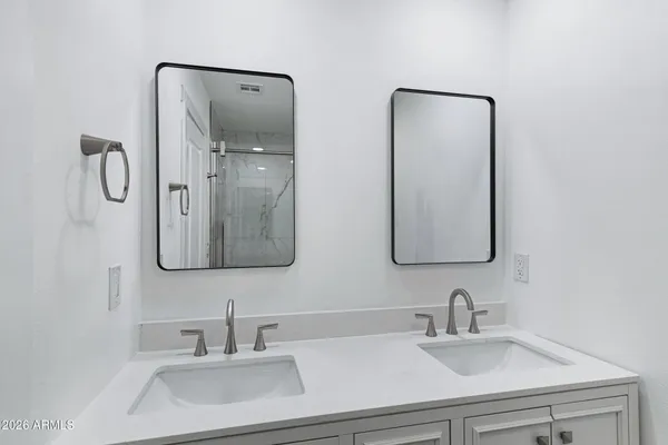 a bathroom with double vanity sinks and a mirror