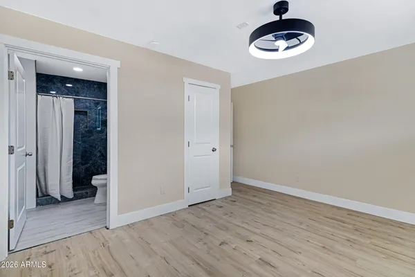 an empty room with a window and wooden floor