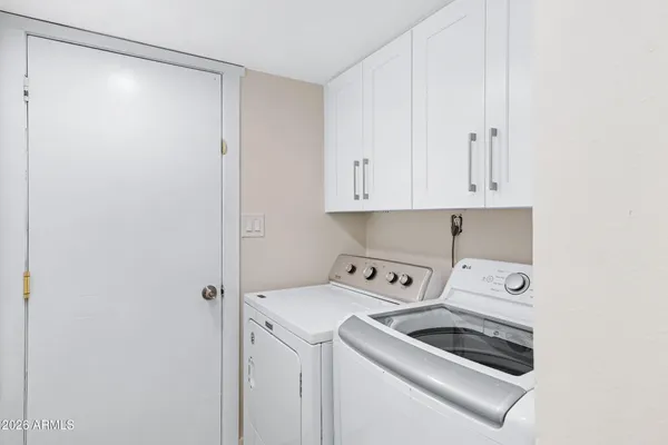 a view of washer and dryer with kitchen in the background