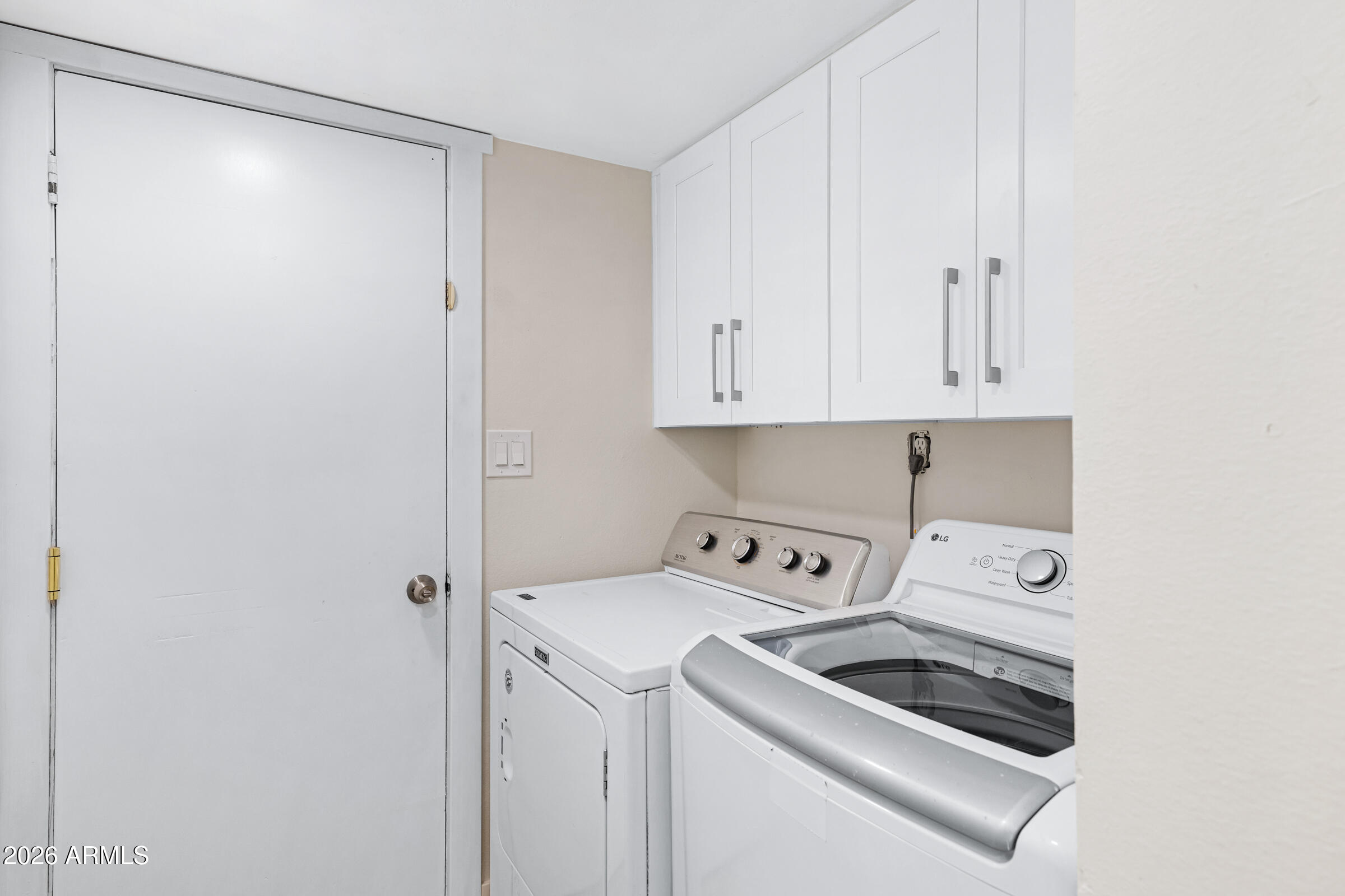 3921 South Kenneth Place Tempe, AZ 85282 - Photo 32 of 43 a view of washer and dryer with kitchen in the background
