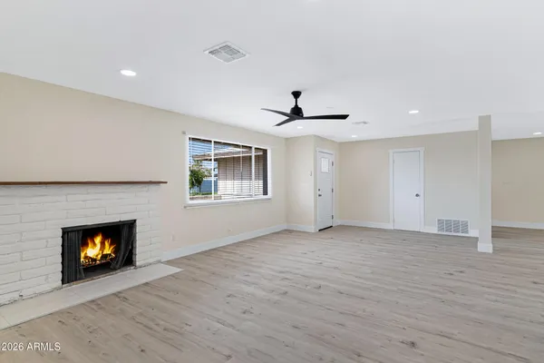 a view of an empty room with a fireplace and a window