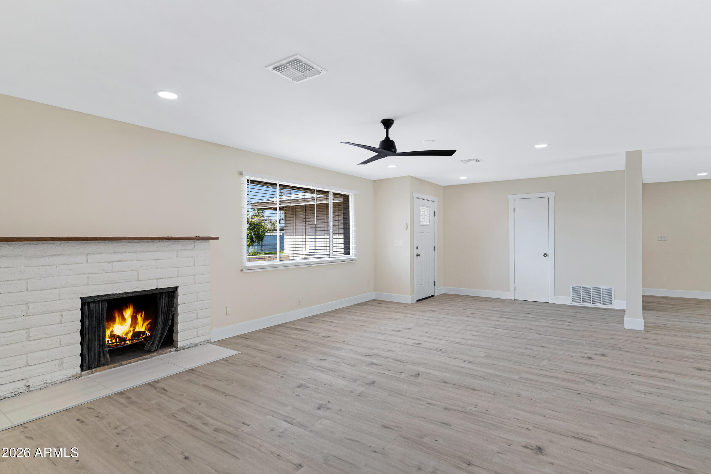 3921 South Kenneth Place Tempe, AZ 85282 - Photo 9 of 43 a view of an empty room with a fireplace and a window