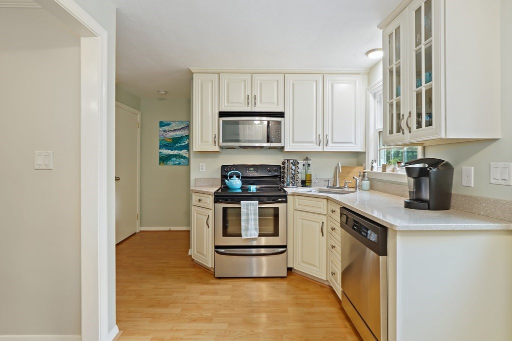 23 Clough Road, Unit 23 Dedham, MA 02026 - Photo 11 of 27 a kitchen with granite countertop a stove and a sink
