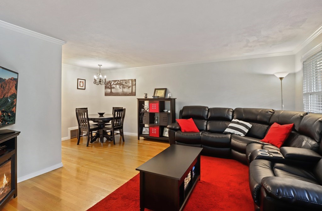 23 Clough Road, Unit 23 Dedham, MA 02026 - Photo 7 of 27 a living room with furniture and a dining table with wooden floor