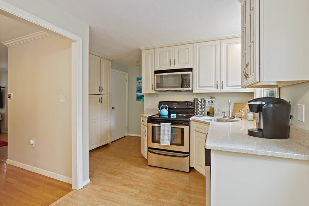 23 Clough Road, Unit 23 Dedham, MA 02026 - Photo 10 of 27 a kitchen with a refrigerator stove and white cabinets