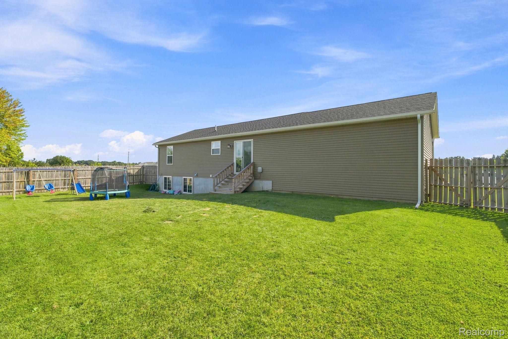 629 Range Road Smiths Creek, MI 48074 - Photo 34 of 36 Expansive lawn with a full privacy fence, wood deck, and walk-out basement