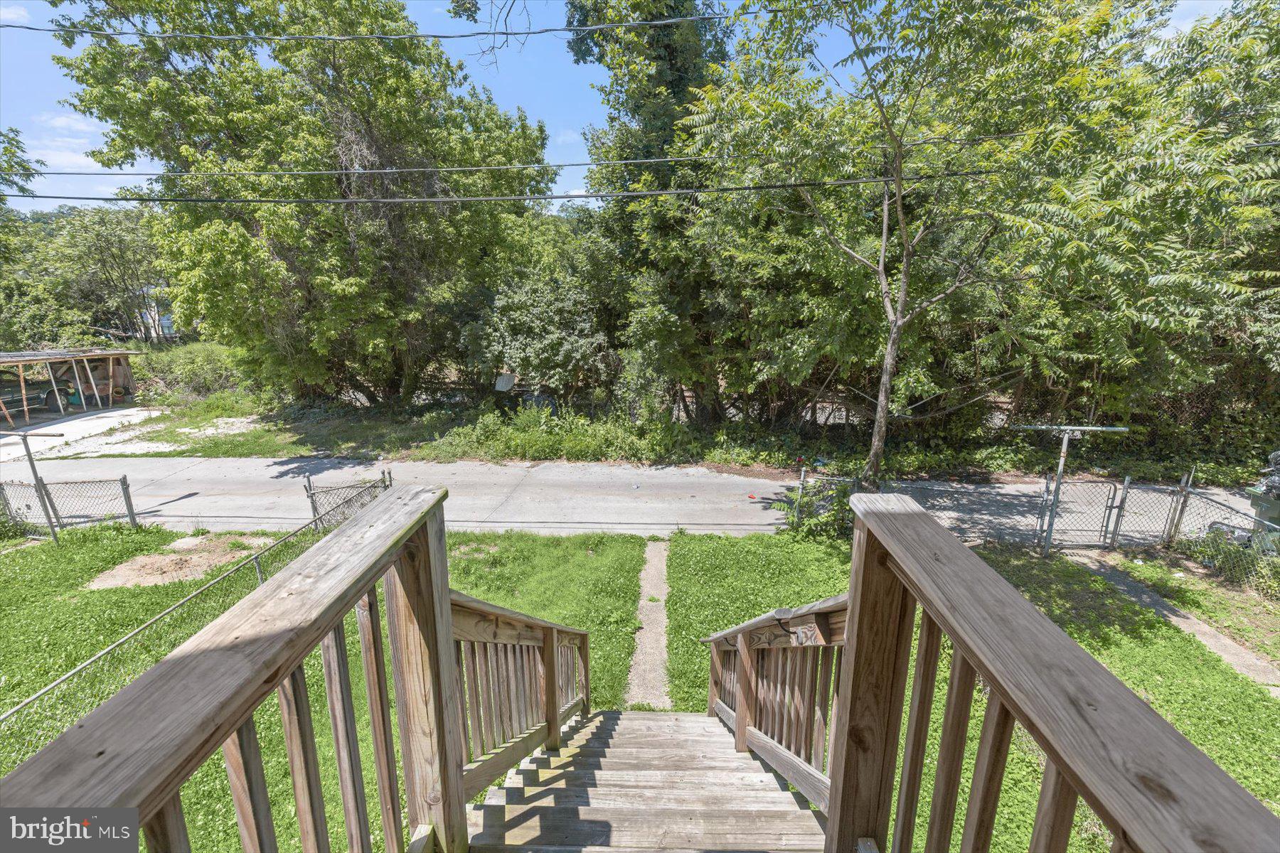 1044 Ellicott Driveway Baltimore, MD 21216 - Photo 19 of 26 a balcony with wooden floor and yard in the back