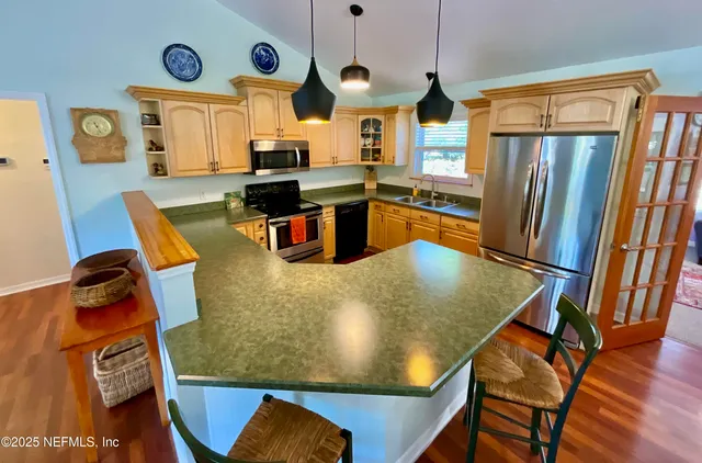 a kitchen with stainless steel appliances granite countertop a stove a sink and a microwave