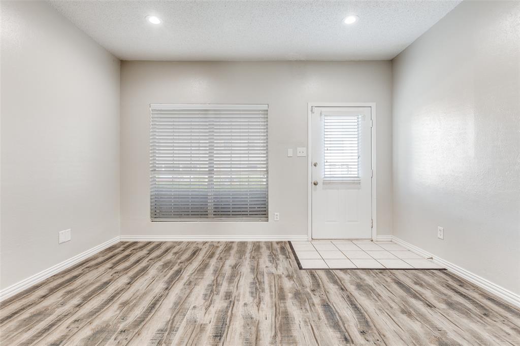 633 Carriagehouse Lane, Unit I6 Garland, TX 75040 - Photo 4 of 24 wooden floor in an empty room with a window