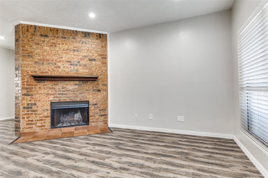 633 Carriagehouse Lane, Unit I6 Garland, TX 75040 - Photo 5 of 24 a view of empty room with wooden floor and fireplace