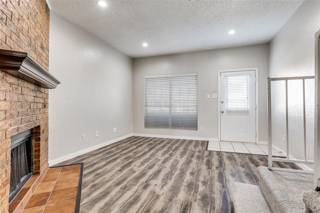 633 Carriagehouse Lane, Unit I6 Garland, TX 75040 - Photo 6 of 24 a view of empty room with wooden floor and fireplace