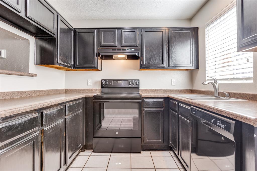 633 Carriagehouse Lane, Unit I6 Garland, TX 75040 - Photo 9 of 24 a kitchen with stainless steel appliances granite countertop a sink stove and cabinets