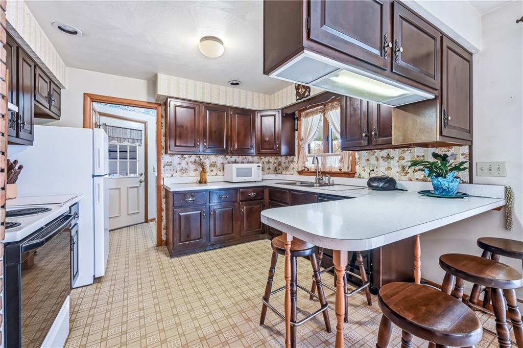 2635 South Keel Ridge Road Hermitage, PA 16148 - Photo 12 of 49 a kitchen with stainless steel appliances granite countertop a sink a stove a refrigerator a stove a dining table and chairs