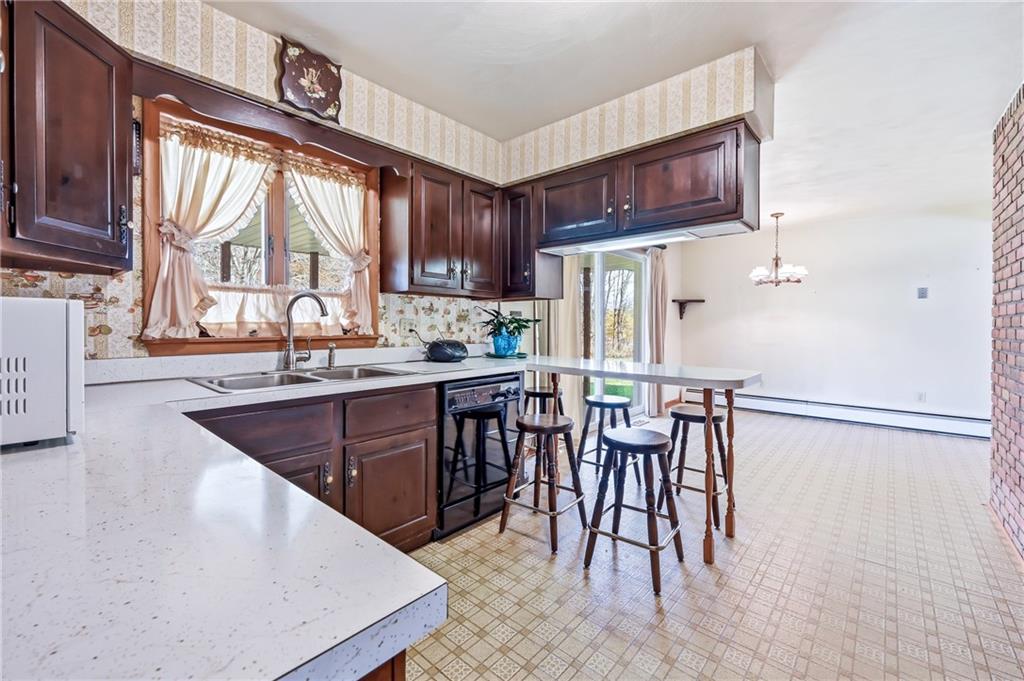2635 South Keel Ridge Road Hermitage, PA 16148 - Photo 10 of 49 a kitchen with stainless steel appliances kitchen island granite countertop a table chairs in it and wooden floors