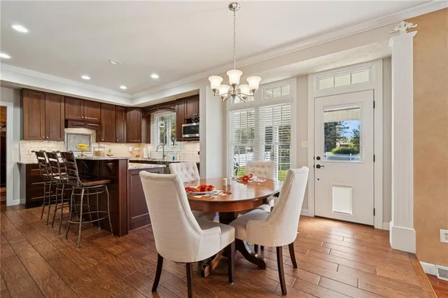 a dining room with furniture a chandelier and wooden floor
