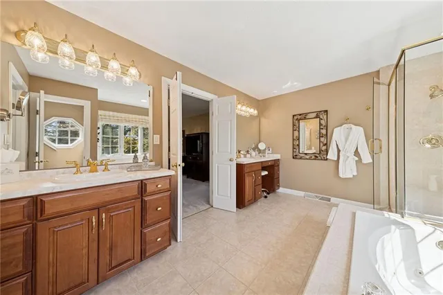 a spacious bathroom with a tub sink and mirror