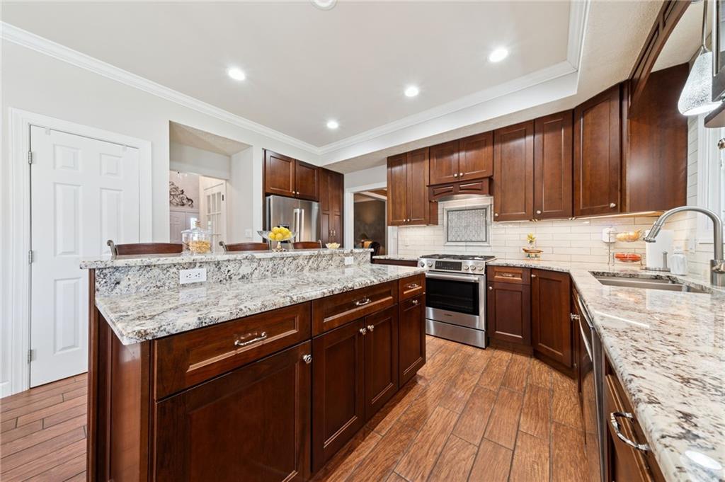 188 Meadow Spring Road Greensburg, PA 15601 - Photo 7 of 43 a kitchen with stainless steel appliances granite countertop wooden cabinets sink and stove top oven