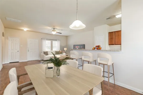 a living room with furniture dining table and wooden floor
