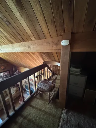 a living room with furniture hard wood floor and a kitchen
