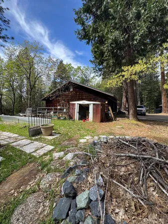 a view of a house with a big yard and large trees