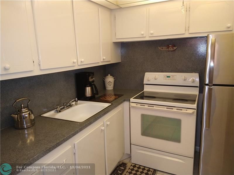 287 Markham M, Unit 287 Deerfield Beach, FL 33442 - Photo 18 of 64 a kitchen with a sink and cabinets